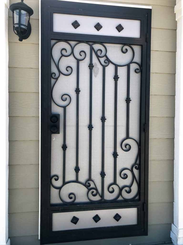 Black wrought iron security screen door with scroll pattern and diamond panels