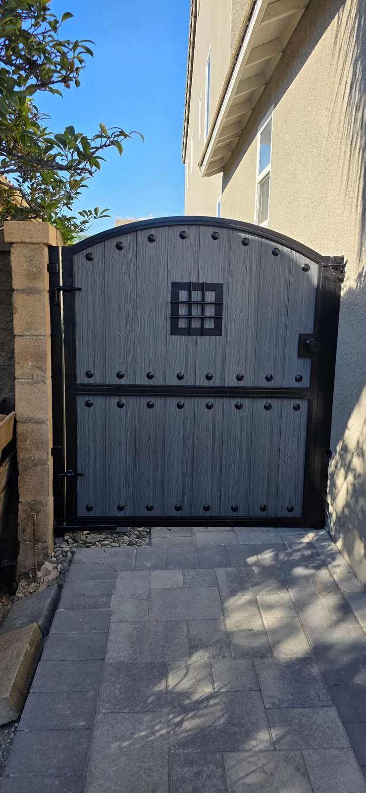 Arched gray side gate with speakeasy grille