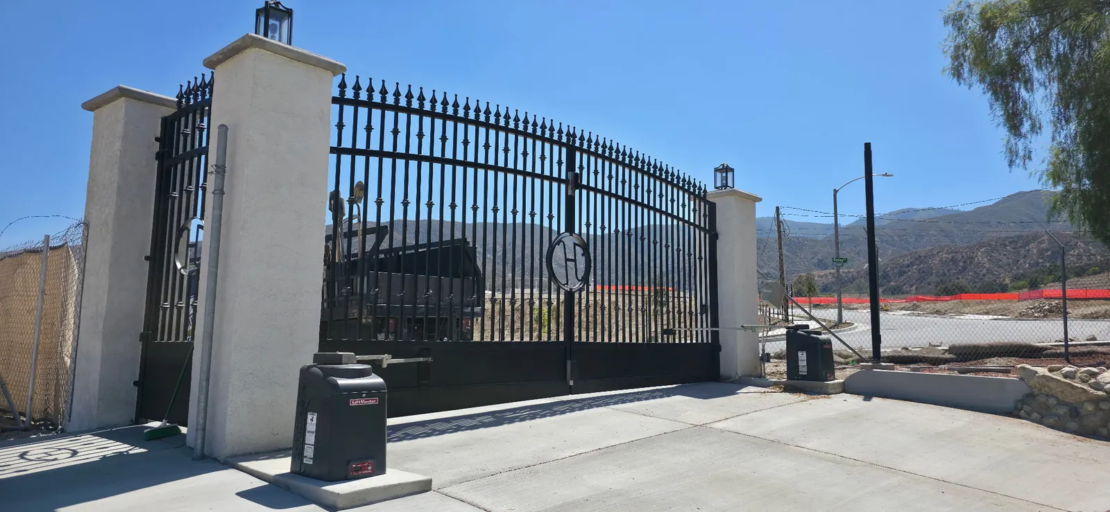 Arched spear-top iron driveway gate with LiftMaster swing gate operators