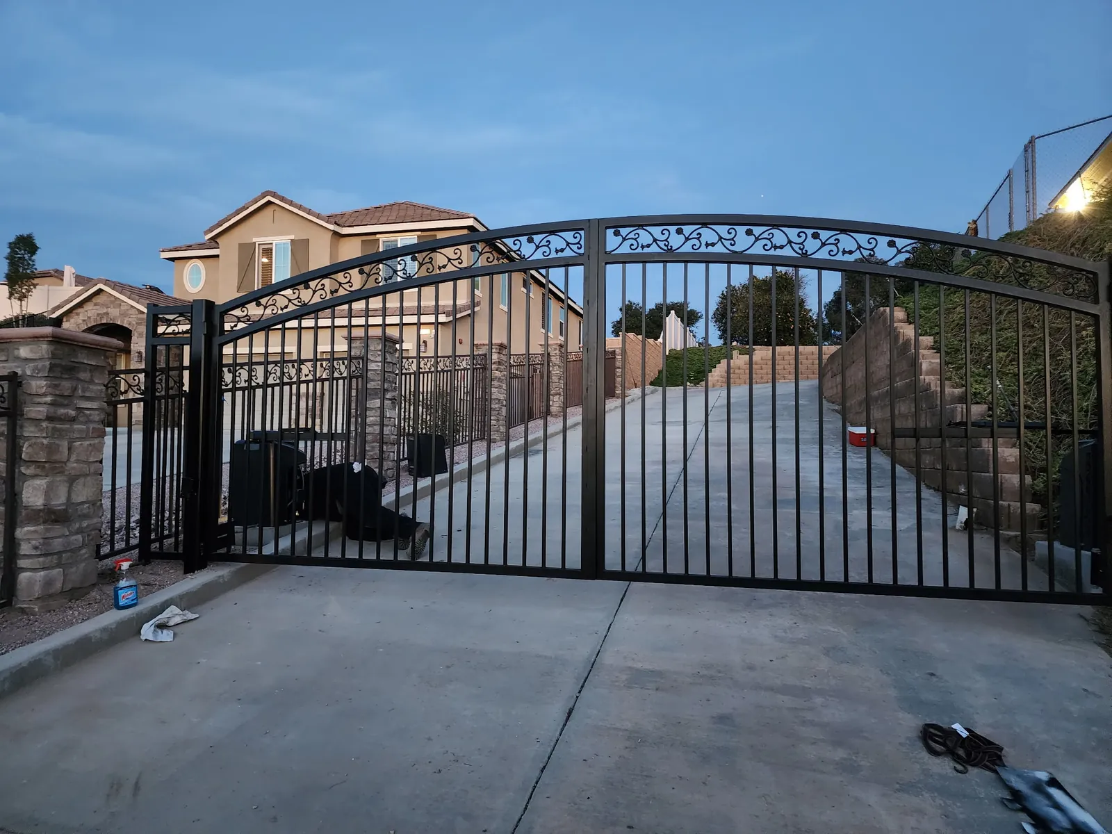 Large arched iron double driveway gate with scroll band