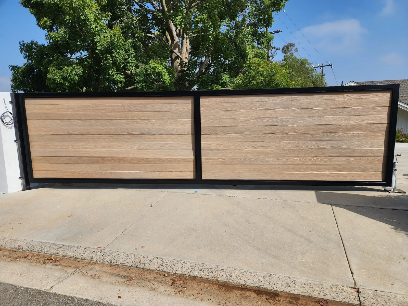 Light wood-look horizontal slat sliding driveway gate