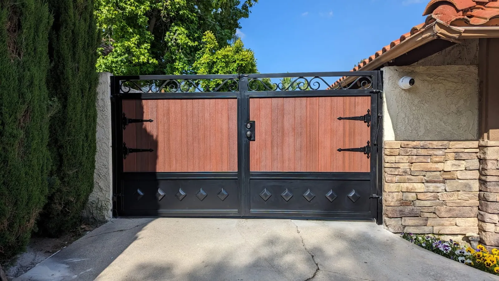 Wood-look double driveway gate with scroll top and strap hinges